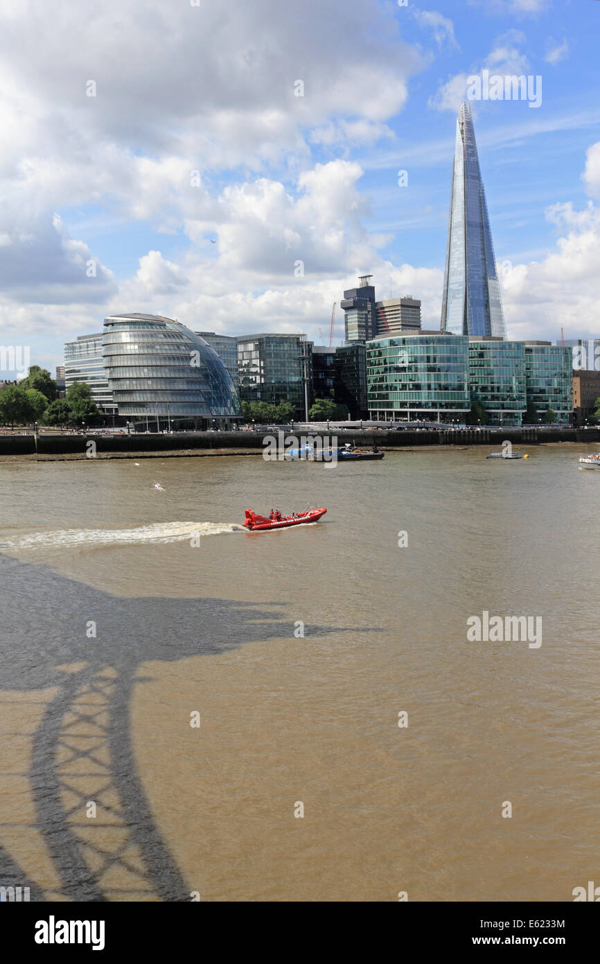 RIB-Boot unterquert die Tower Bridge und die Scherbe an der Themse in London, England UK Stockfoto