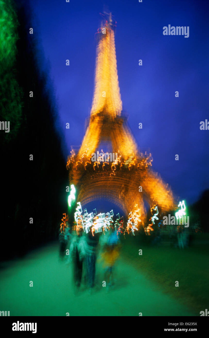 Rückansicht der Paare, die zu Fuß in Richtung Eiffelturm bei Nacht Stockfoto