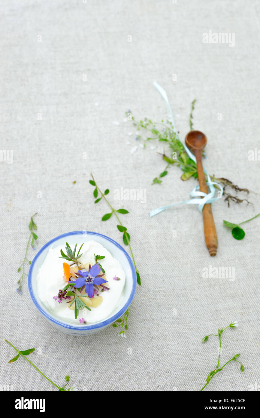Schüssel Crème fraîche dekoriert mit Kräuter und essbare Blumen Stockfoto