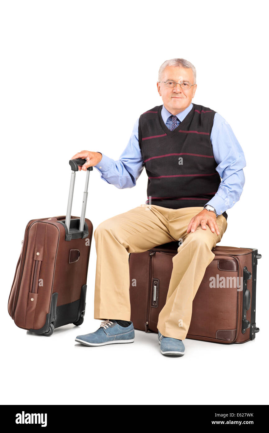 Ältere Mann sitzt auf seinem Gepäck Stockfoto