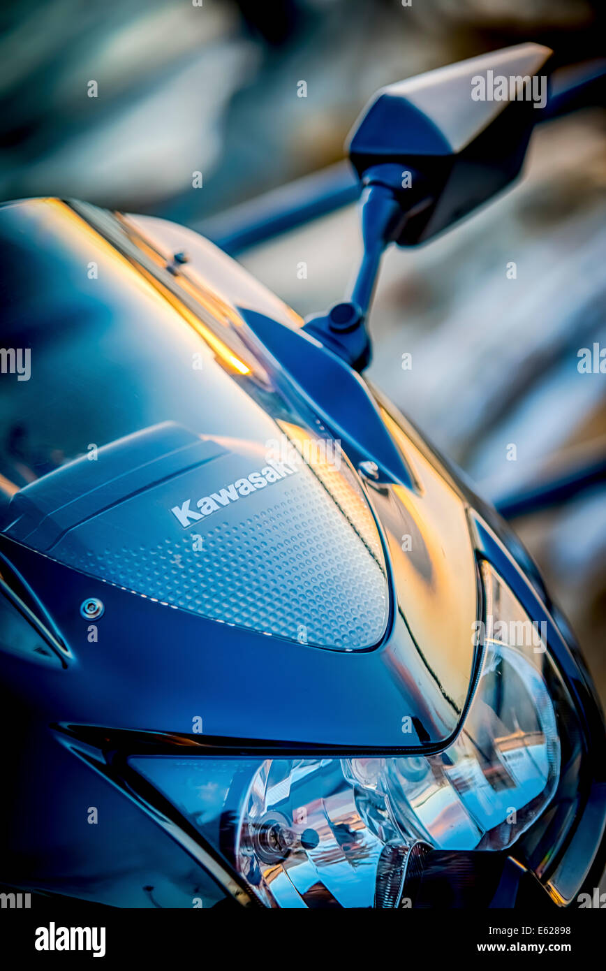 Sonnenuntergang spiegelt sich in der Windschutzscheibe eines blauen Kawasaki-Motorrad Stockfoto