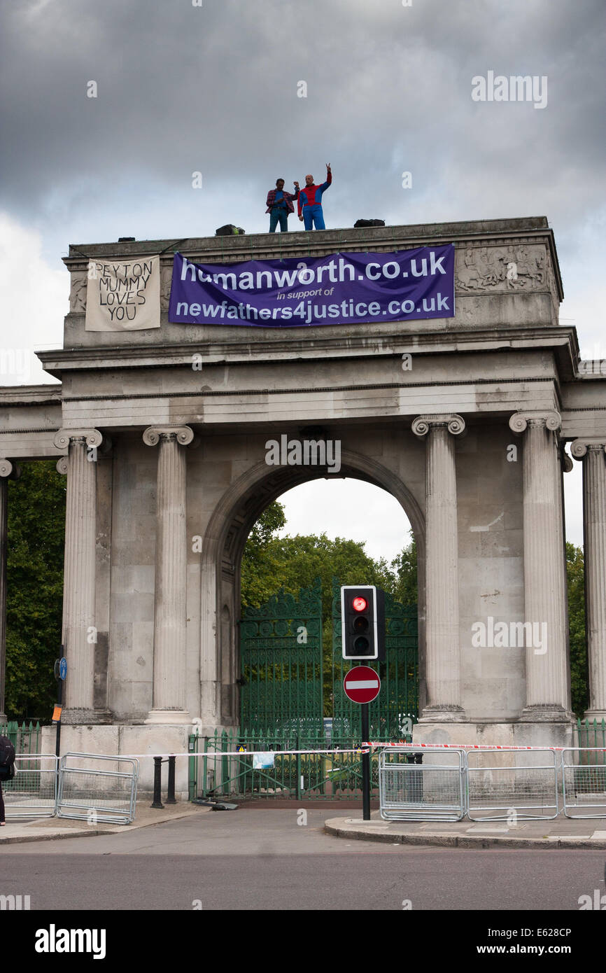 London, 12. August 2014. Zwei Demonstranten von Väter für Gerechtigkeit Welle an den Durchgangsverkehr aus Spitze Decimus Burtons Ionischen Bildschirm Eingang zum Hyde Park angrenzend an Apsley House am Hyde Park Corner. Bildnachweis: Paul Davey/Alamy Live-Nachrichten Stockfoto