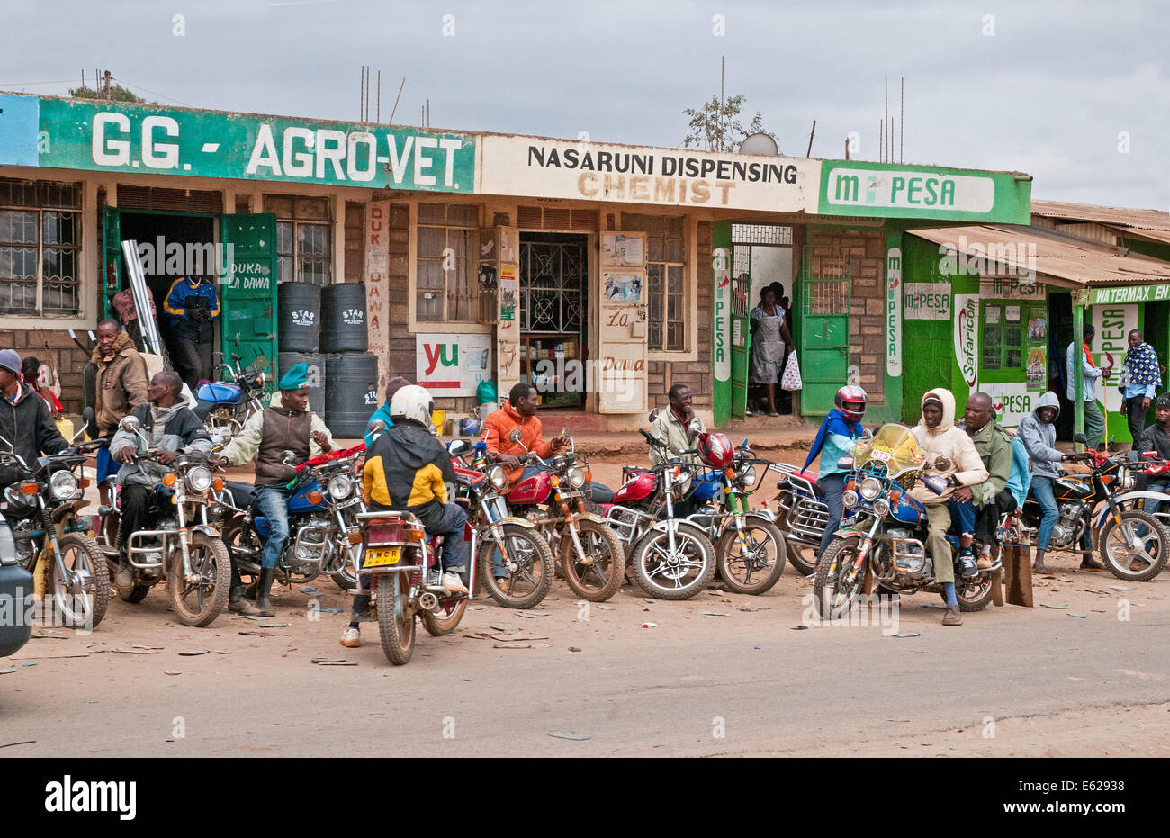 Motorrad taxis außerhalb Wellblechhütten und am Straßenrand Geschäfte Duka Hotel am Kaijado unterwegs Namanga Nairobi Kenia Afrika Stockfoto