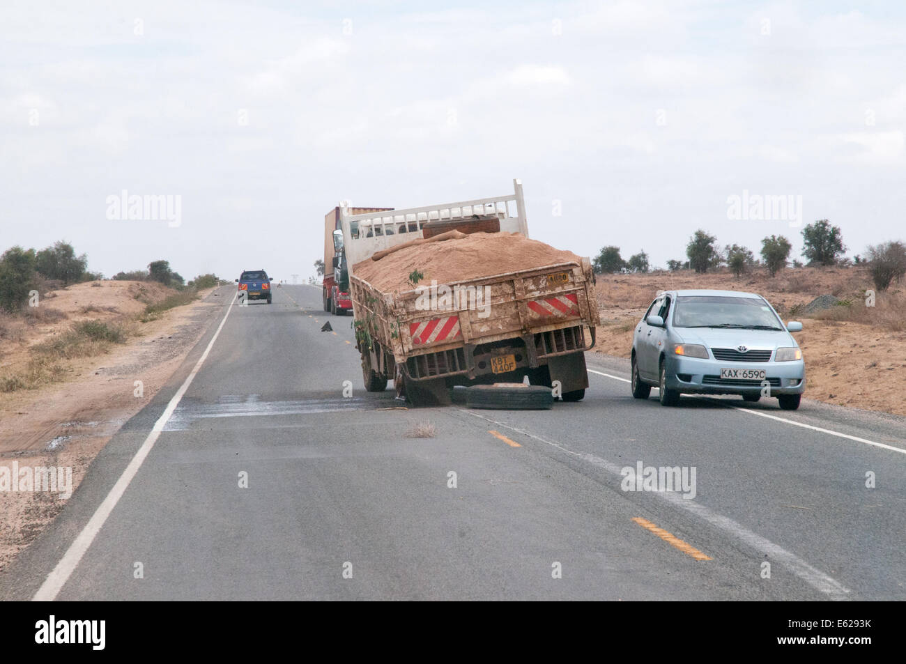 Verkehr vorbei unterteilt LKW LKW mit gebrochenen Feder hinten auf Namanga Nairobi Road Kenia in Ostafrika Stockfoto