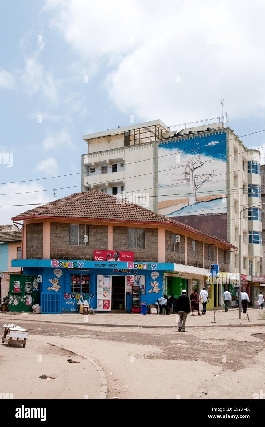 Typische minderwertige Geschäfte oder Dukas und benachbarte sechsstöckige Wohnblock mit Wandbild im Bezirk Süd C Nairobi Kenia Afrika S Stockfoto