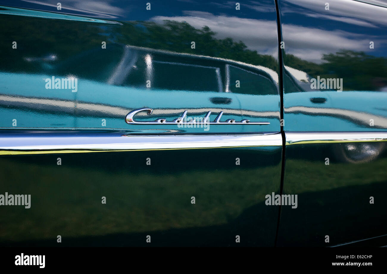 Chrom-Cadillac-Abzeichen und trim mit einem blauen Ford Chevrolet spiegelt sich in der schwarzen Lackierung Stockfoto