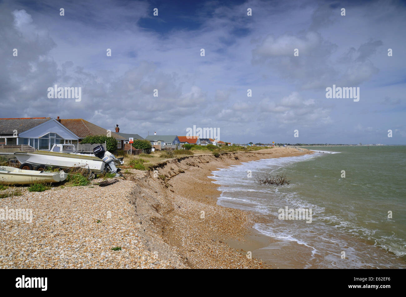 Pagham, West Sussex, UK.12 August 2014.Coastal Erosion führt weiter entlang der Südküste durch den letzten heftige Stürme beschleunigt. Bungalows am Strand von Pagham sind jetzt in der Nähe das vorrückende Meer. Adur District Council werden Anstrengungen unternommen, um die Eigenschaften des LKW offensichtlich heute große Felsen auf dem Kies kippen zu schützen. Einige Einheimische sagen, es ist zu spät und glauben, dass, wenn die großen Spieß Aufbau wieder verletzt wird, wie es in der Vergangenheit war die weitere Erosion ist unvermeidlich. Bildnachweis: David Burr/Alamy Live-Nachrichten Stockfoto