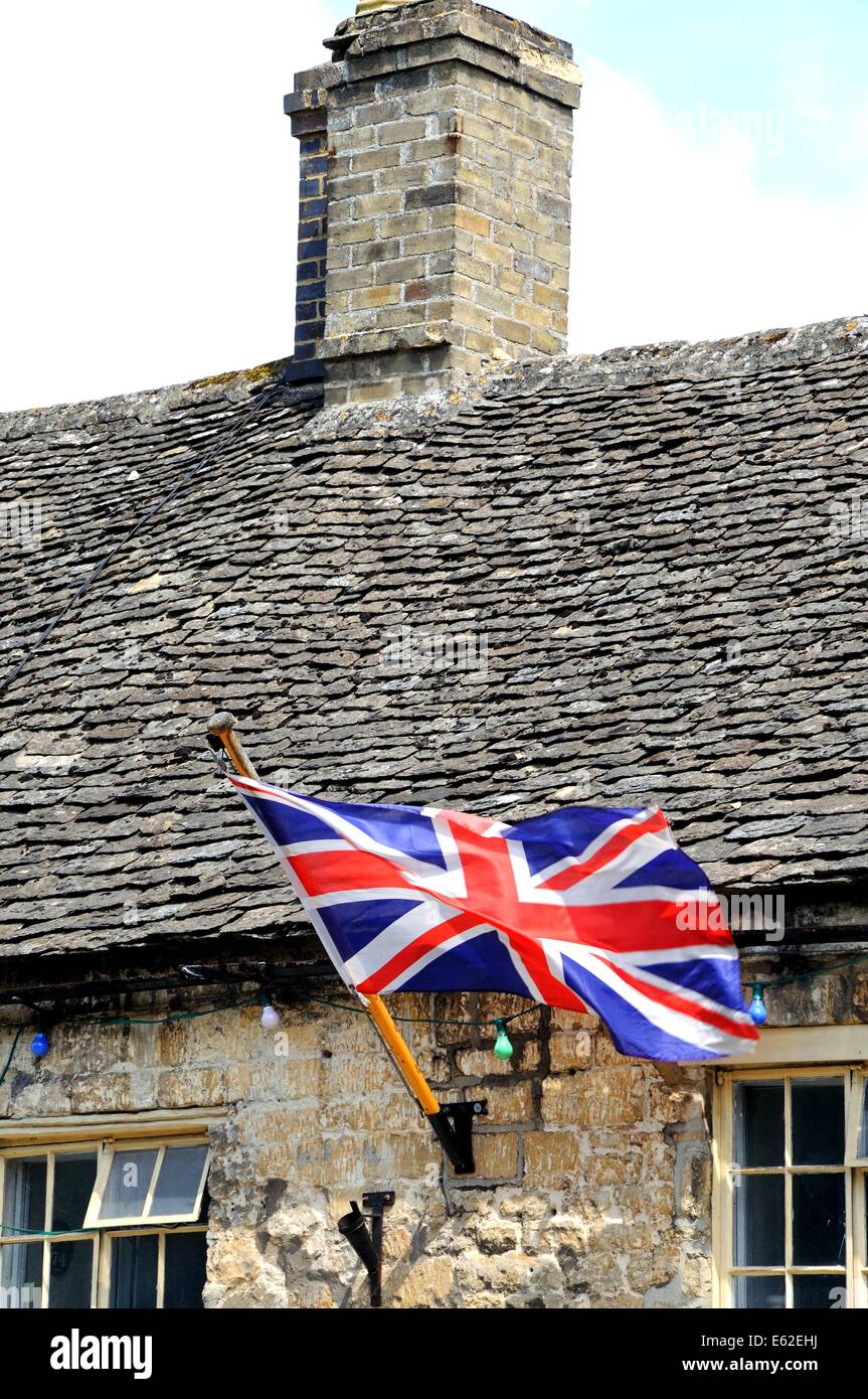 Anschluß-Markierungsfahne auf ein traditionelles Cotswold-Gebäude entlang der High Street, Burford, Oxfordshire, England, UK, Westeuropa. Stockfoto