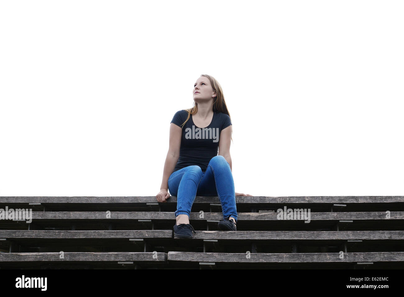 nachdenkliche junge Frau sitzt auf freien Flug der Treppe Stockfoto