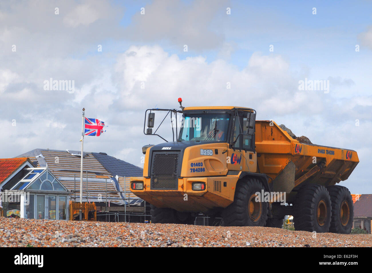Pagham, West Sussex, UK.12 August 2014.Coastal Erosion führt weiter entlang der Südküste durch den letzten heftige Stürme beschleunigt. Bungalows am Strand von Pagham sind jetzt in der Nähe das vorrückende Meer. Adur District Council werden Anstrengungen unternommen, um die Eigenschaften des LKW offensichtlich heute große Felsen auf dem Kies kippen zu schützen. Einige Einheimische sagen, es ist zu spät und glauben, dass, wenn die großen Spieß Aufbau wieder verletzt wird, wie es in der Vergangenheit war die weitere Erosion ist unvermeidlich. Bildnachweis: David Burr/Alamy Live-Nachrichten Stockfoto