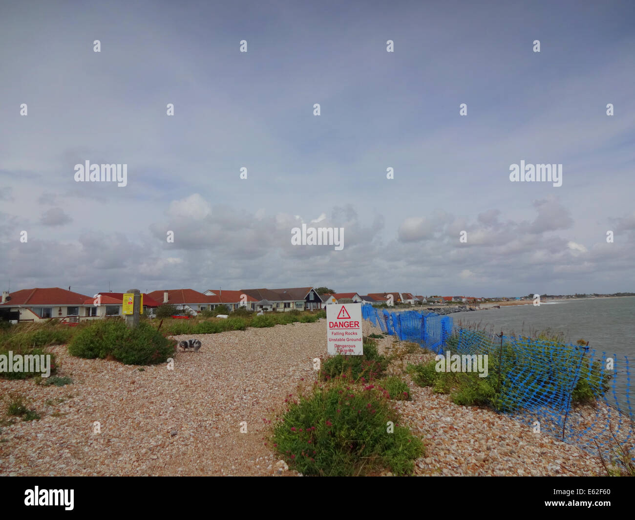 Pagham, West Sussex, UK. 12. August 2014. Küstenerosion führt weiter entlang der Südküste, beschleunigt durch den letzten heftige Stürme. Bungalows am Strand von Pagham sind jetzt in der Nähe das vorrückende Meer. Adur District Council werden Anstrengungen unternommen, um die Eigenschaften des LKW offensichtlich heute große Felsen auf dem Kies kippen zu schützen. Einige Einheimische sagen, es ist zu spät und glauben, dass, wenn die großen Spieß Aufbau wieder verletzt wird, wie es in der Vergangenheit war die weitere Erosion ist unvermeidlich. Bildnachweis: David Burr/Alamy Live-Nachrichten Stockfoto