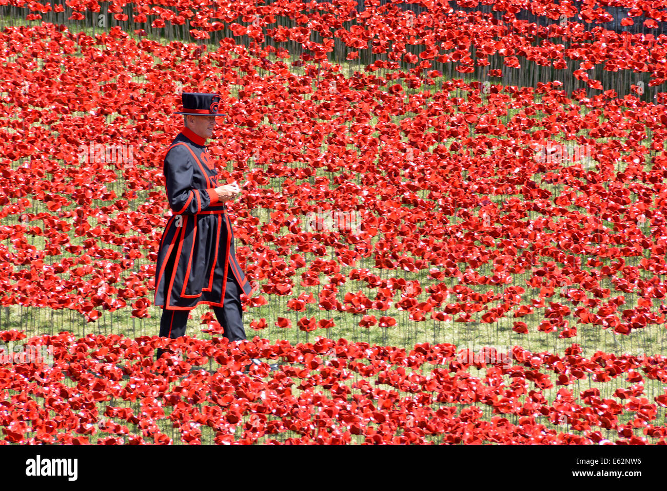 Yeoman Warder & Bereich der Keramik Mohnblumen "Blut fegte Ländereien & Meere rot" 1. Weltkrieg Tribut in den trockenen Graben an der Tower von London Tower Hamlets UK Stockfoto