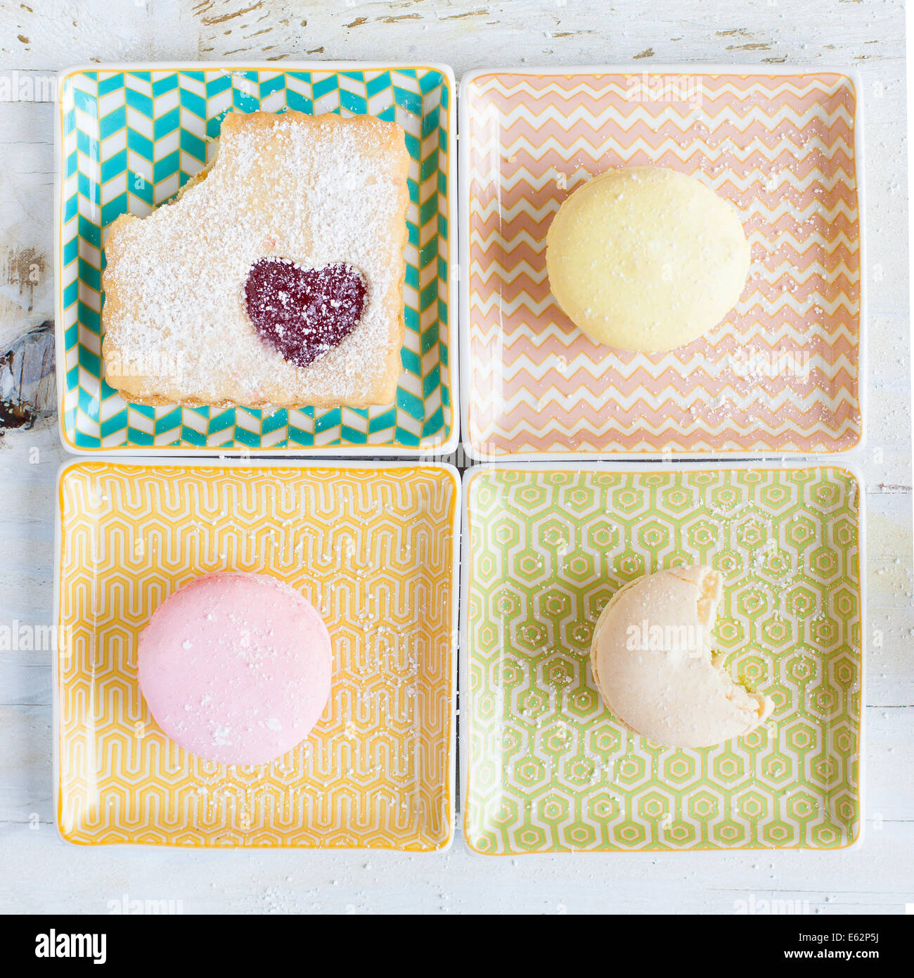 Macarons und Cookie auf quadratischen Pastell Platten Stockfoto