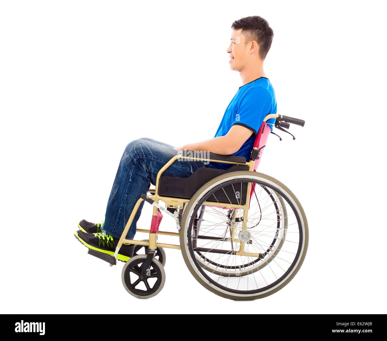 hoffnungsvoller junger Mann sitzt auf einem Rollstuhl im studio Stockfoto
