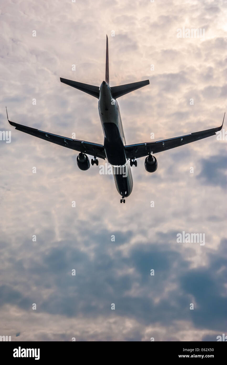 Passage Airline Jet absteigend Landeanflug gegen einen dramatischen Hintergrund der sonnenbeschienenen Wolken. Atlanta, Georgia. (USA) Stockfoto