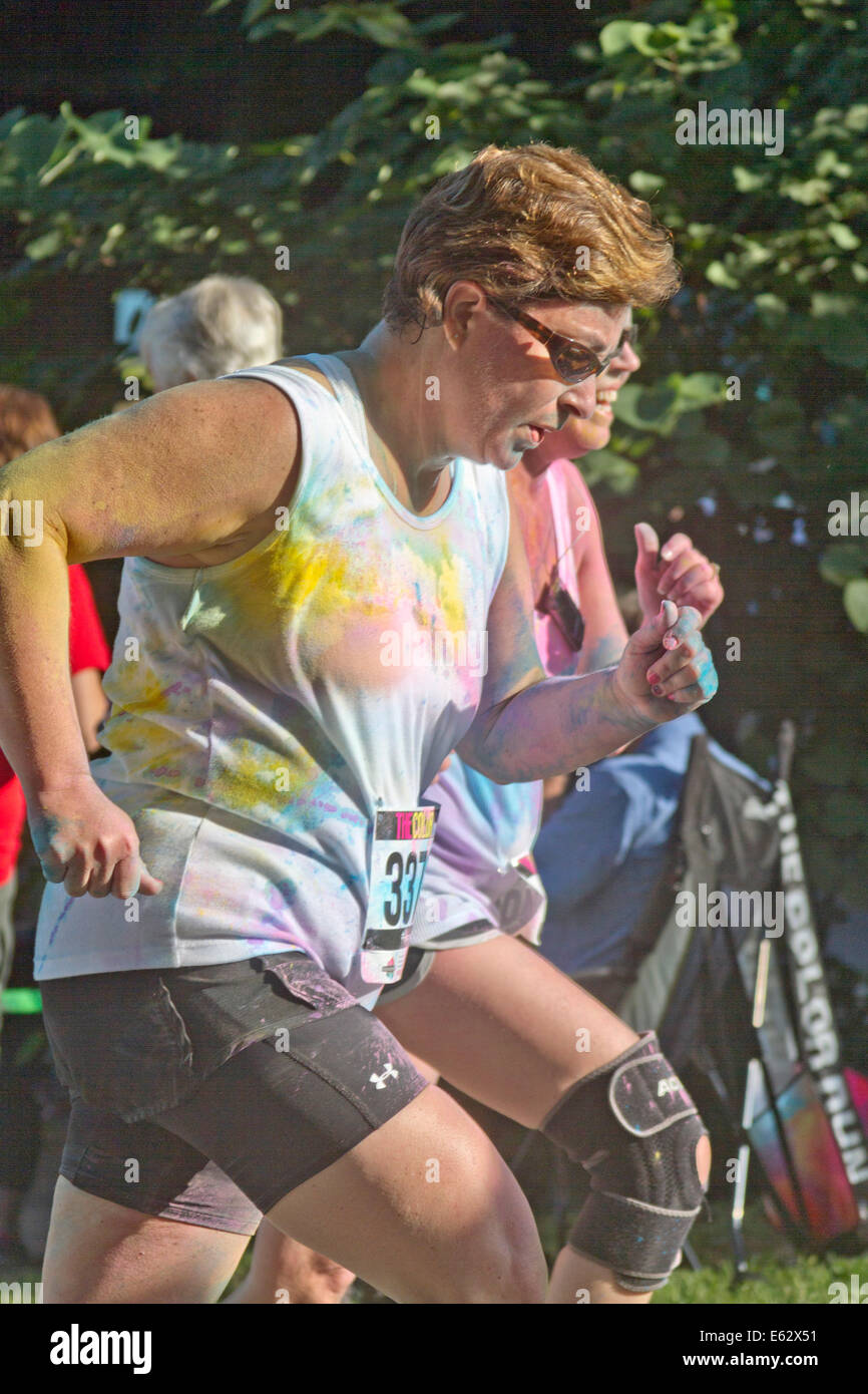 Asheville, North Carolina, USA - 26. Juli 2014: Frauen Läufer mit bunten Farben wie die Zeit die die Happy asheville Co spritzte Stockfoto