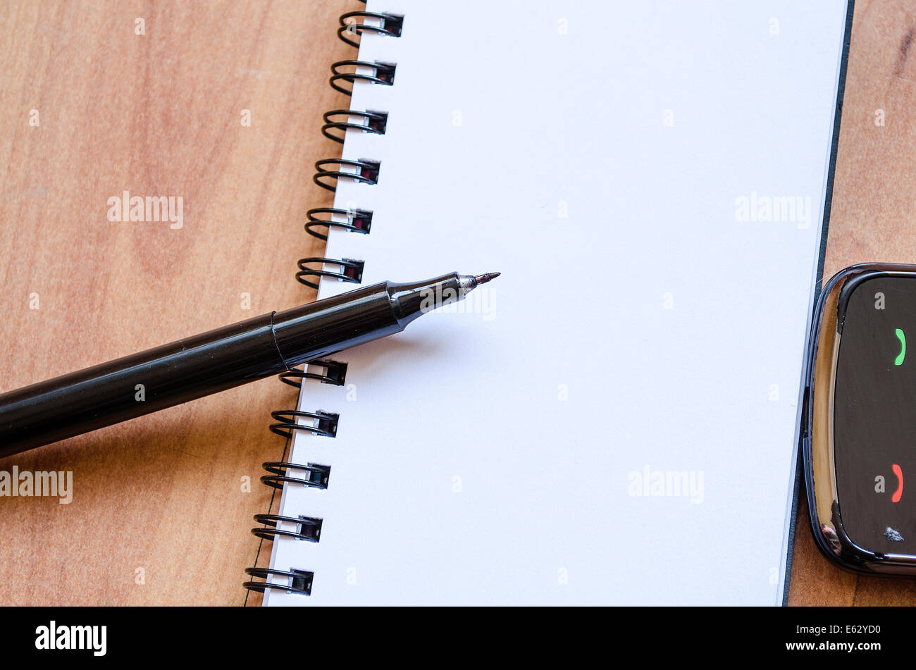 Leere Notebook und Tinte Stift auf einem Schreibtisch aus Holz und alten Telefon Stockfoto