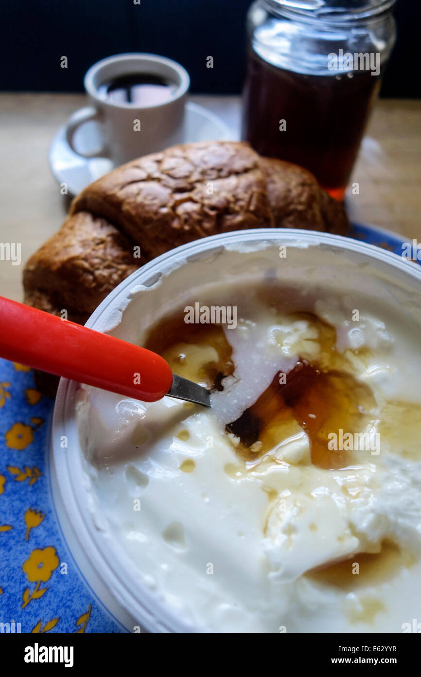 Griechische Küche. Joghurt mit Thymian-Honig, Kaffee und Croissant. Stockfoto