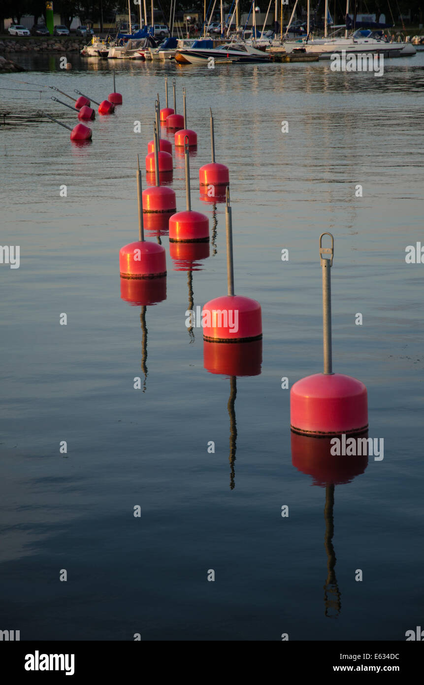 Reihe von roten Bojen im Wasser reflektiert Stockfoto