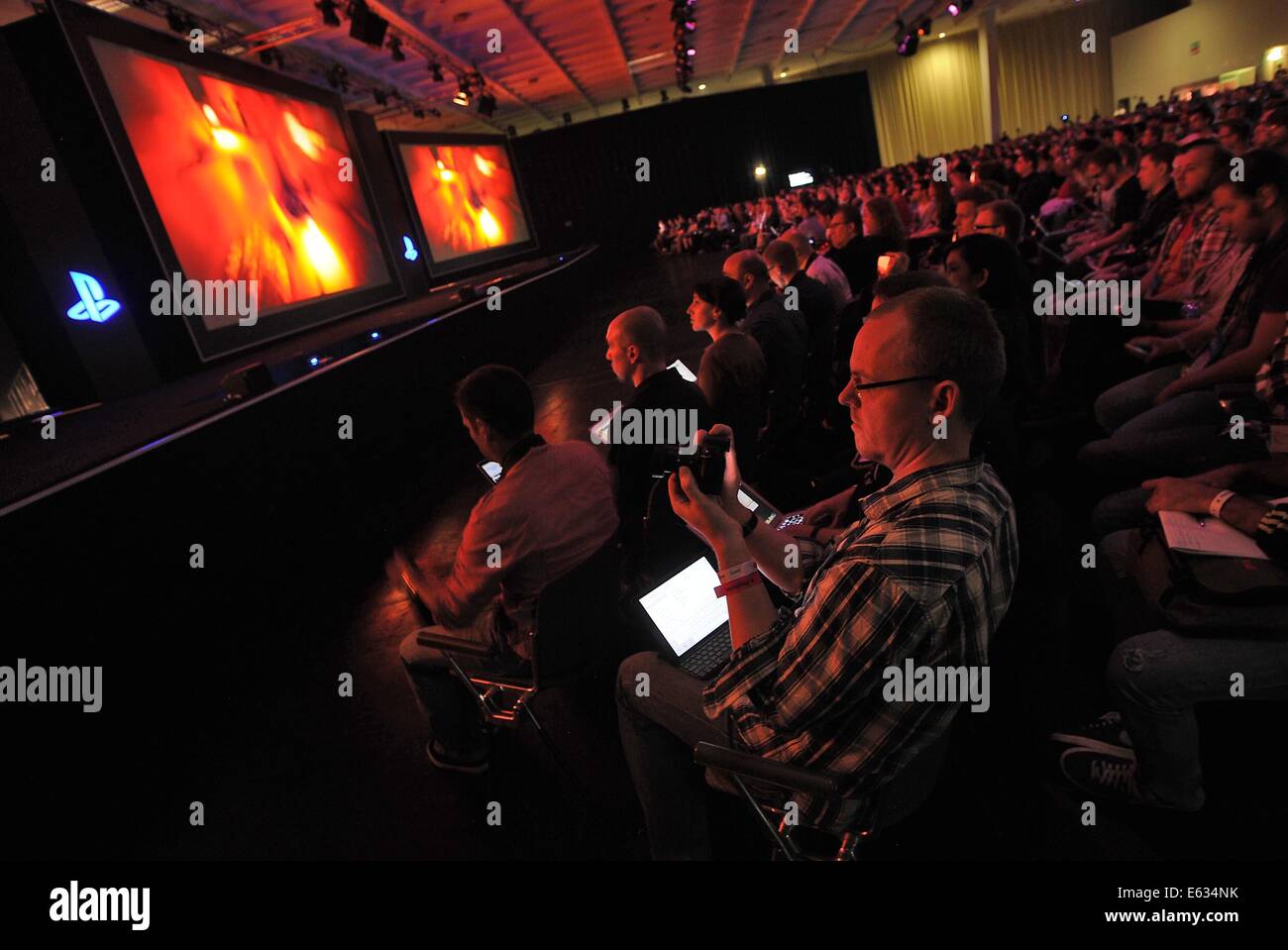 Köln, Deutschland. 12. August 2014. Besucher nehmen Teil in einer Pressekonferenz von Sony Computer Entertainment, für eine Presention der neuen Spiele für die Playstation Konsole vor der Computerspiele Spiele Messe "Gamescom" in Köln, Deutschland, 12. August 2014. Sony verkauft 10 Millionen Einheiten der neuen Playstation 4 Konsole seit seiner Markteinführung vor 6 Monaten. Foto: Henning Kaiser/Dpa/Alamy Live News Stockfoto