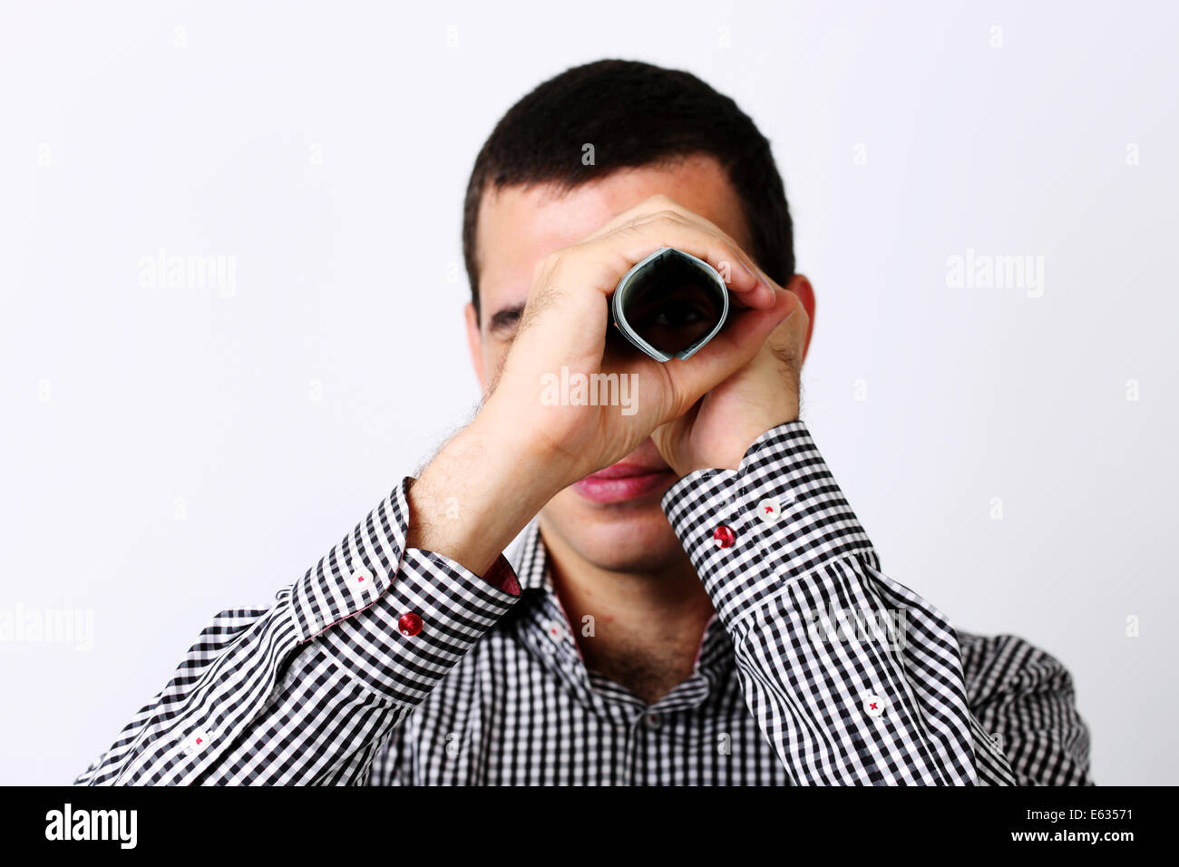 Geschäftsmann sieht in die Kamera durch Rohr von Dollar Stockfoto