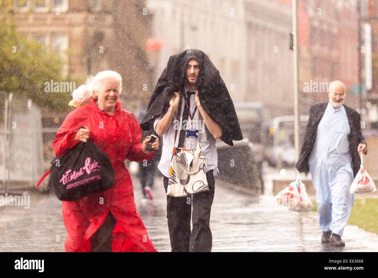 11-08-14.MANCHESTER, in England.  Wetterbild. Ein Platzregen Regen zwingt Mancunians in Deckung gehen Stockfoto