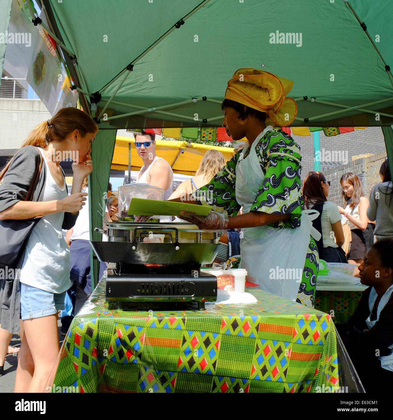 Frau Wahl Essen zu einem afrikanischen Garküche in einem Straßenmarkt in Shoreditch, London Stockfoto
