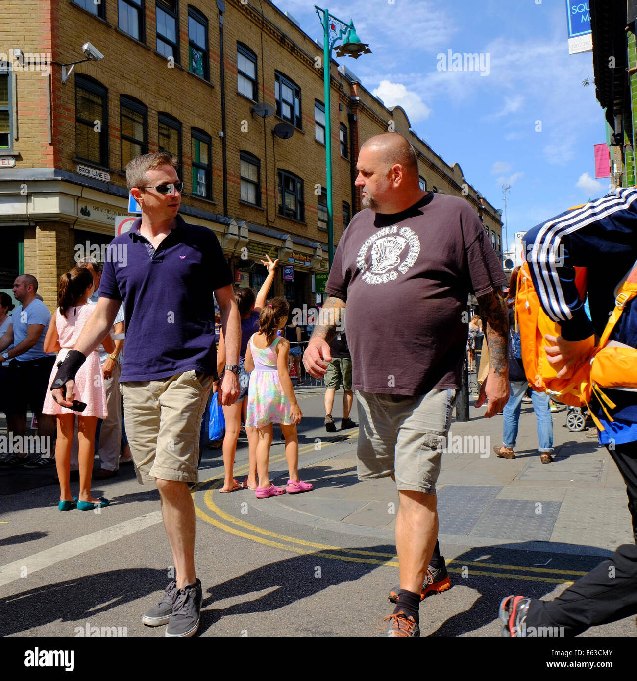 Dünner Mann und fetter Mann mit Bierbauch wandern in Brick Lane, Shoreditch, London Stockfoto