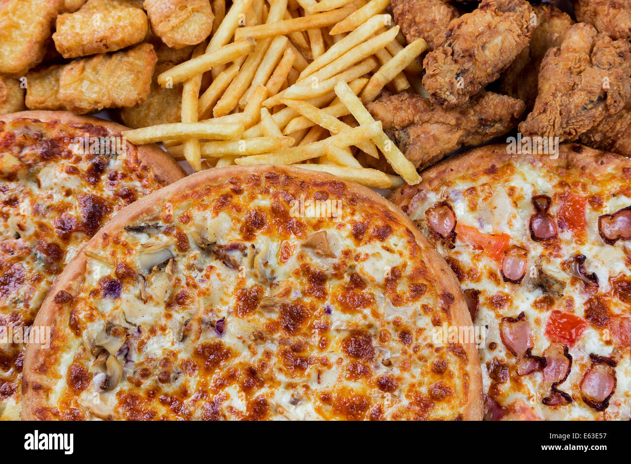 Gruppe von Fastfood - Hähnchen-Nuggets, Beine, Pizzen und Braten Kartoffeln Stockfoto