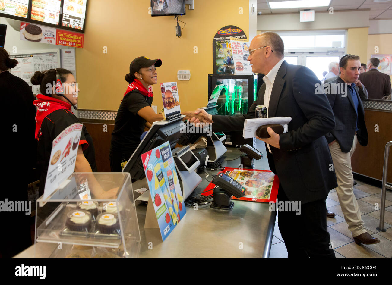 Fast-Food-Restaurant-Kette Carls Jr. CEO Andrew Puzder, grüßt Mitarbeiter an einem Standort in Austin, Texas Stockfoto