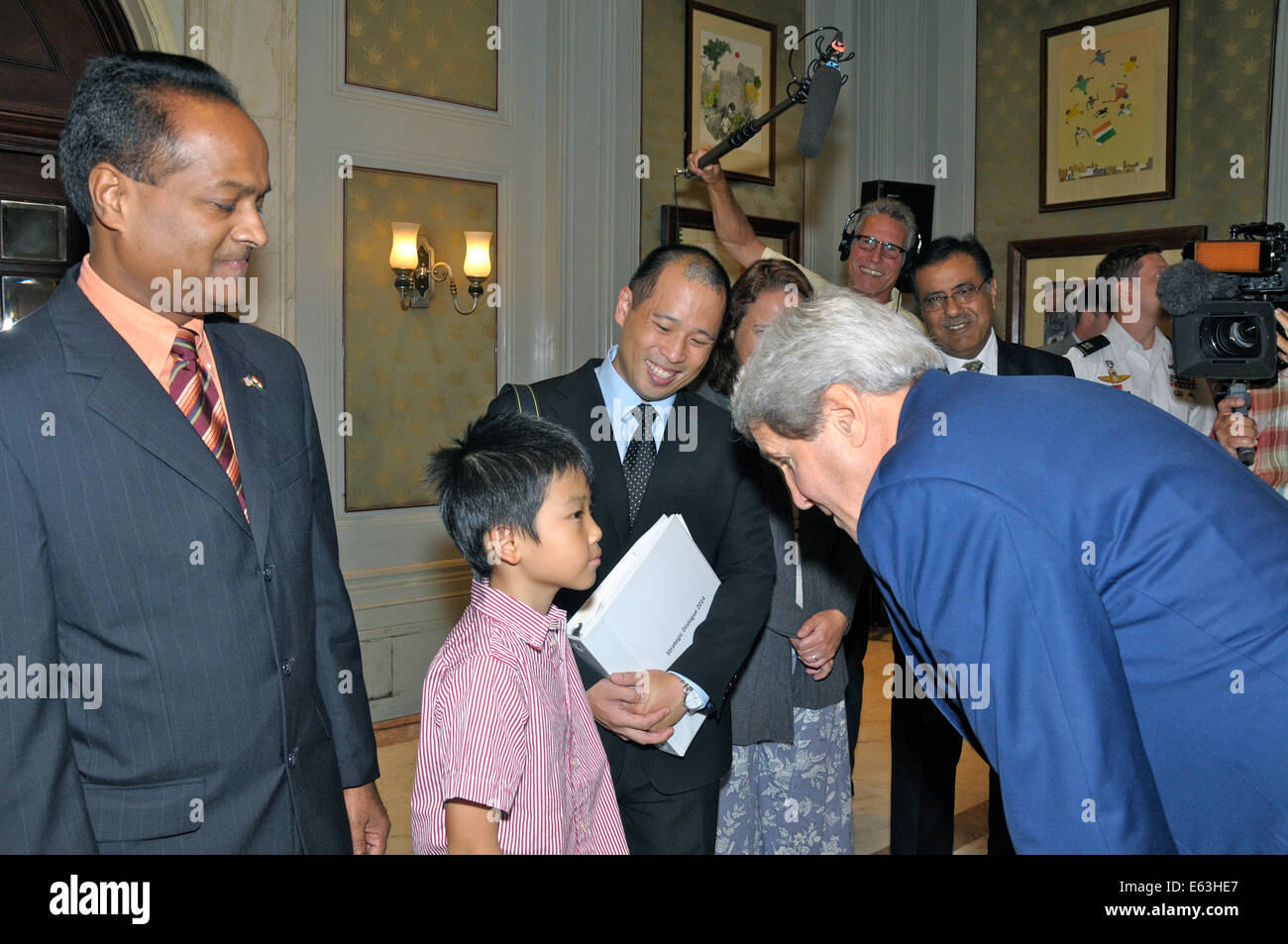 US-Außenminister John Kerry dauert einen Moment, um mit dem Sohn eines Mitarbeiters der Botschaft während seines Besuches in New Delhi am 1. August 2014 chatten. Stockfoto