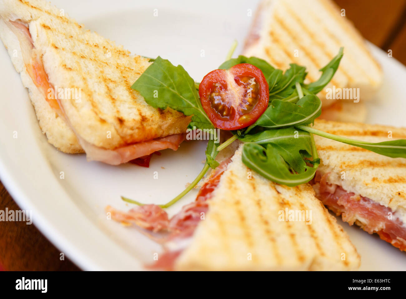 Toast mit Schinken, Rucola und Baby Gebackene Tomaten Stockfoto