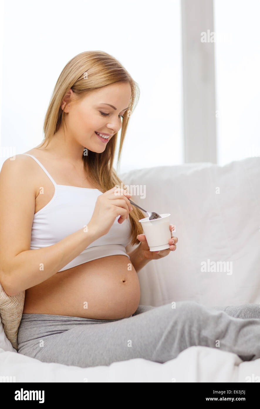 glücklich schwanger Frau mit Joghurt Stockfoto