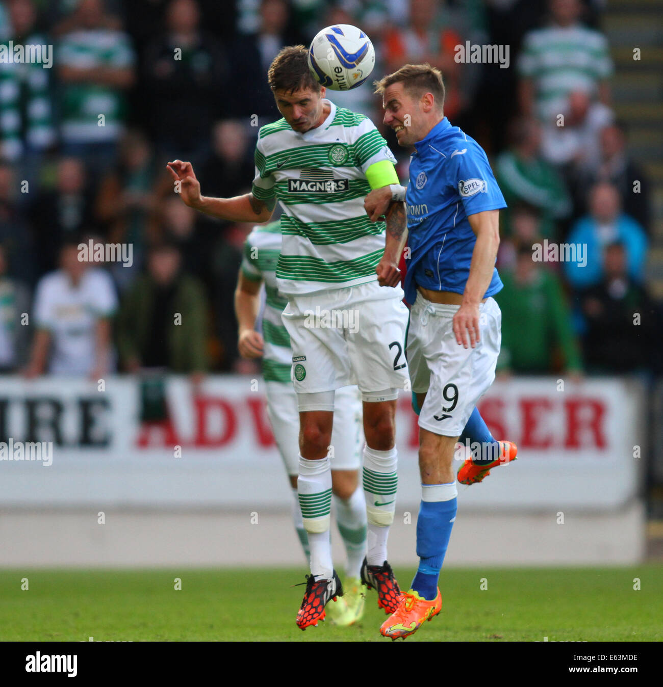 Perth, Schottland. 13. August 2014. Scottish Professional Football League Spiel zwischen St. Johnstone und Celtic aus McDairmid Park.Mikael Lustig, der Kapitän an der Stelle Scott Brown war, schlägt Steven MacLean in der Luft Credit: Action Plus Sport/Alamy Live News Stockfoto