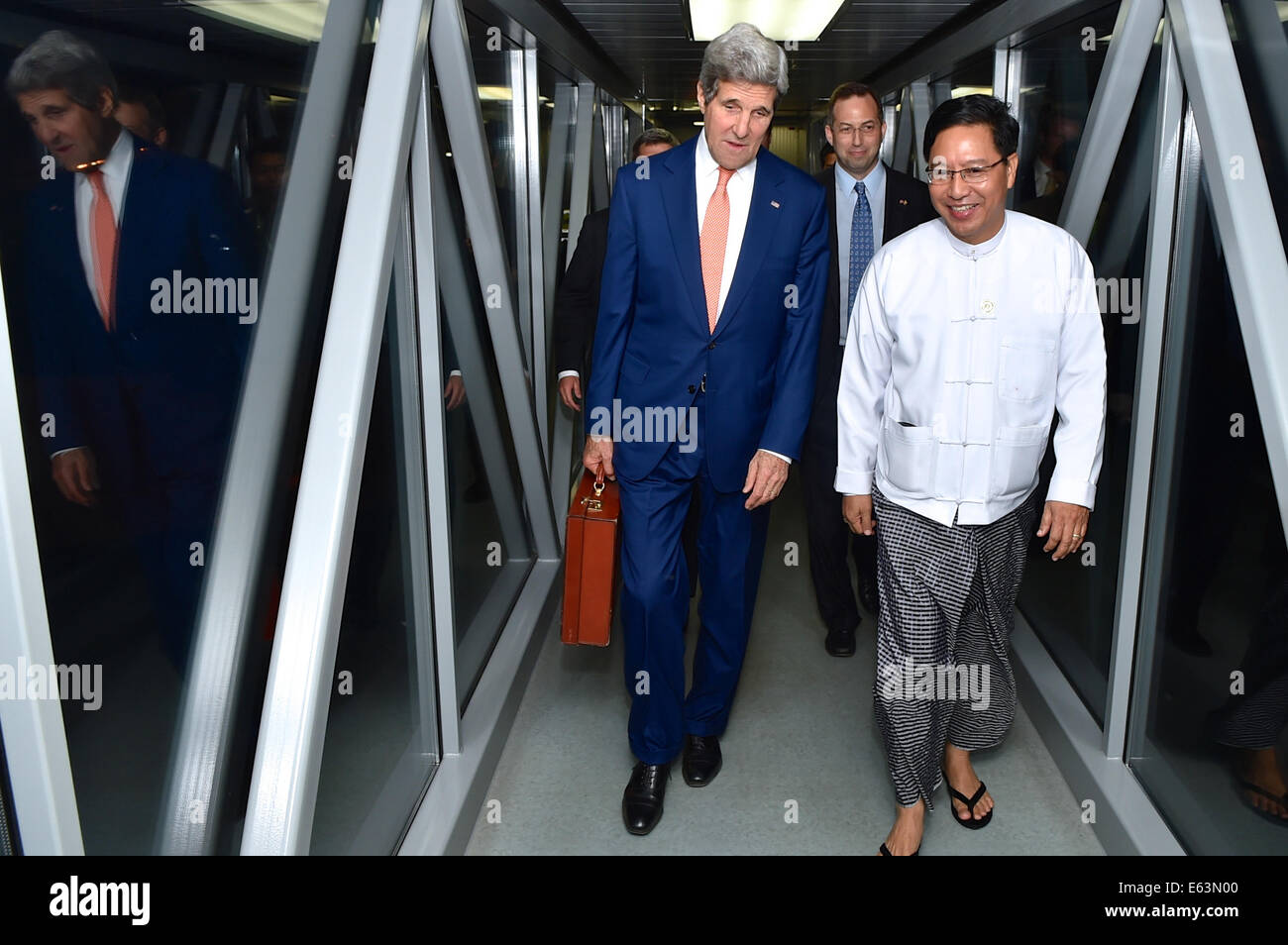 Ein Beamter der birmanischen Protokoll geht mit US-Außenminister John Kerry bei seiner Ankunft in Naypyitaw, Birma, am 8. August 2014, im Vorfeld eines Treffens der ASEAN-Mitglieder. Stockfoto