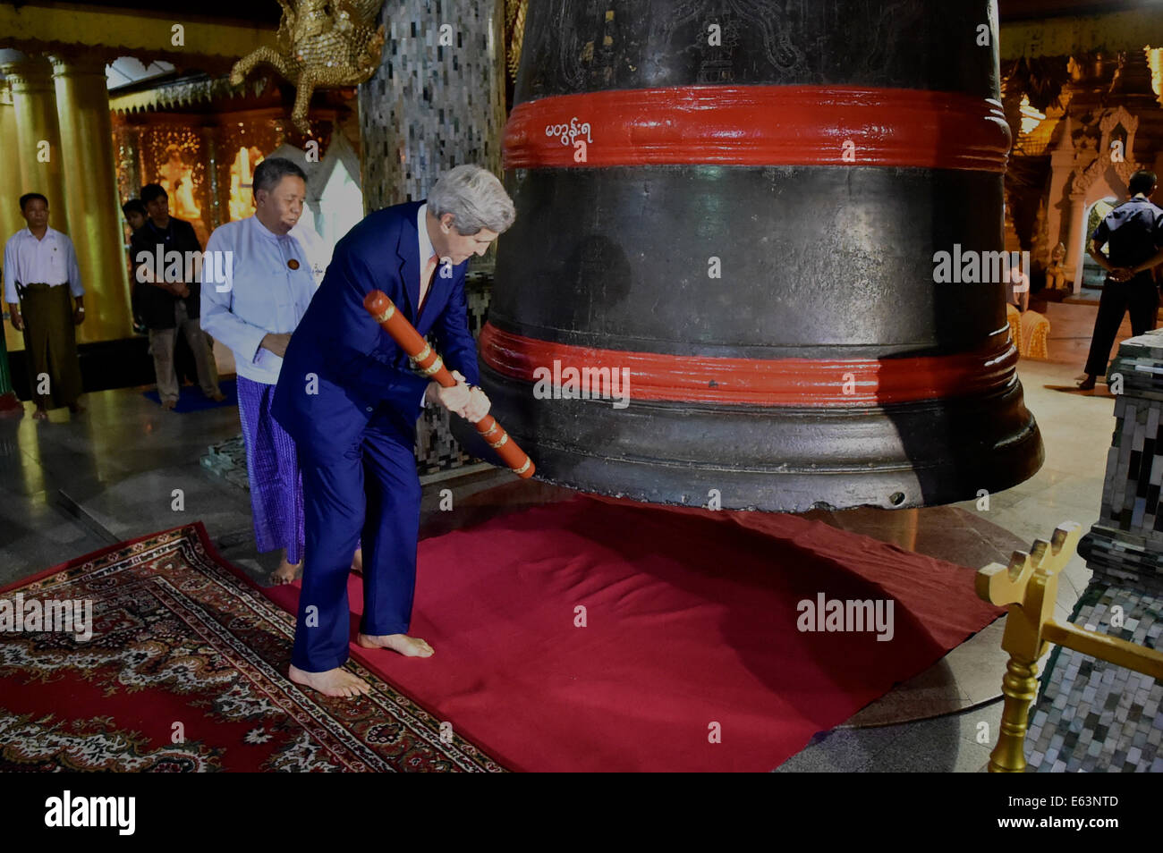 US-Außenminister John Kerry schlägt eine Glocke dreimal während des Besuchs der buddhistischen Shwedagon-Pagode in Rangun, Burma, am 10. August 2014. Stockfoto