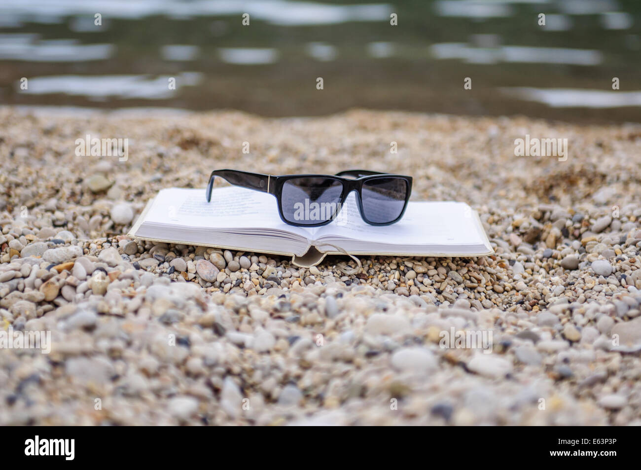 Offenes Buch am Strand nahe dem Meer Stockfoto