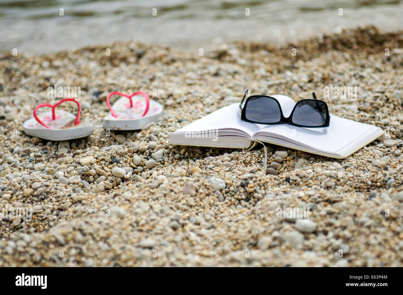 Offenes Buch am Strand nahe dem Meer Stockfoto