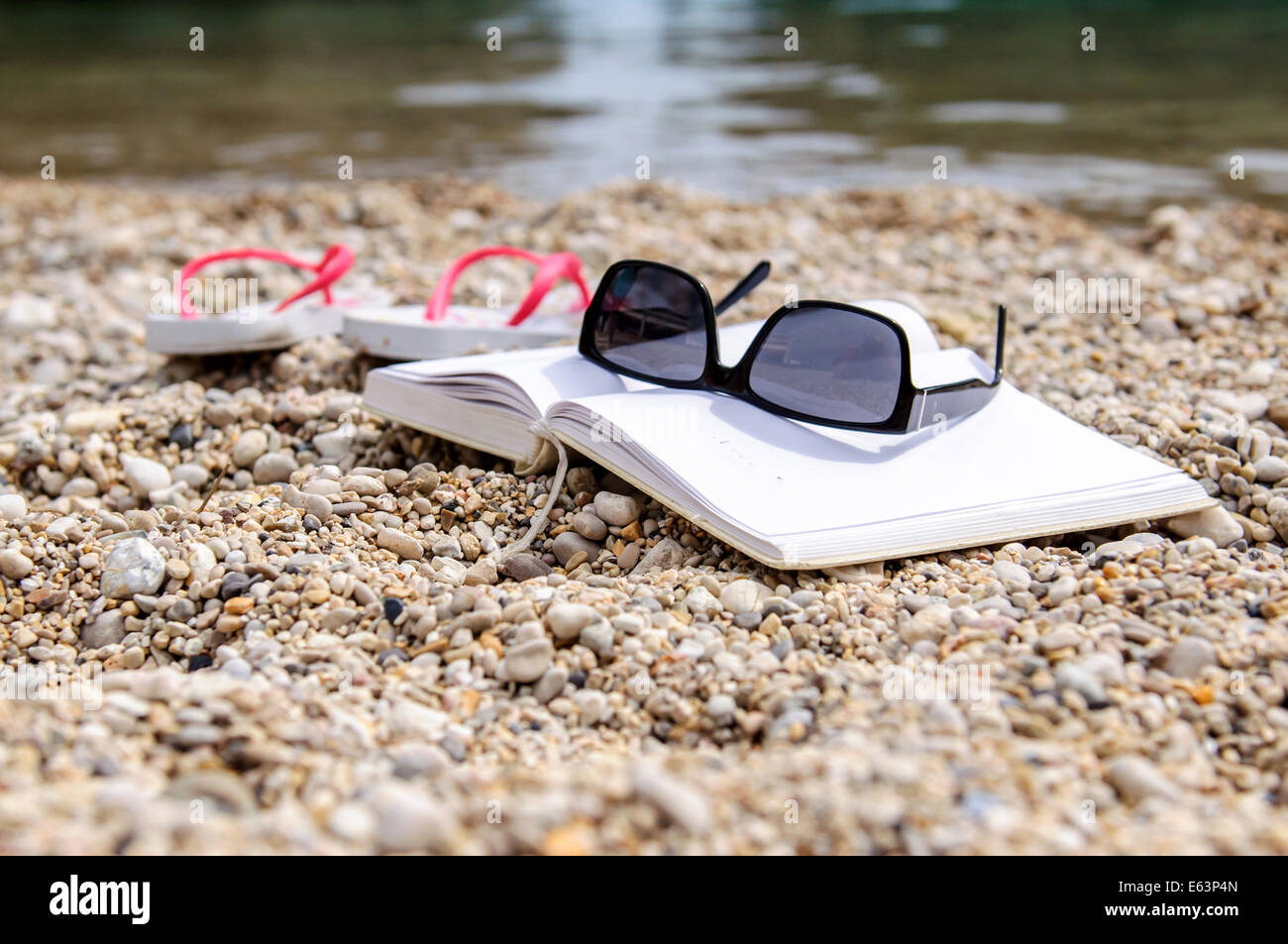 Offenes Buch am Strand nahe dem Meer Stockfoto