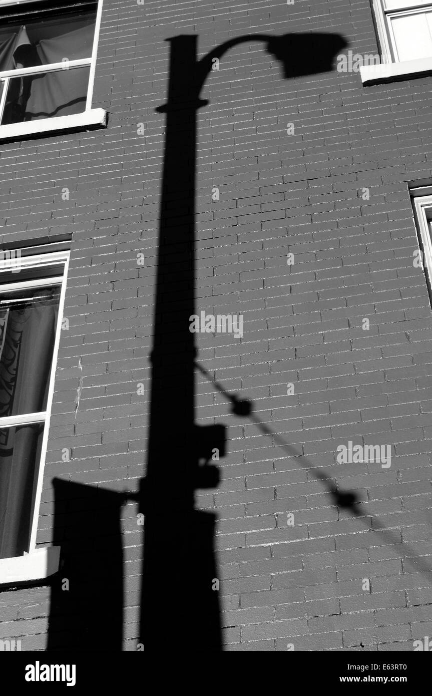 Schwarz / weiß-Bild von einem Laternenpfahl Schatten auf die Wand eines Gebäudes Stockfoto
