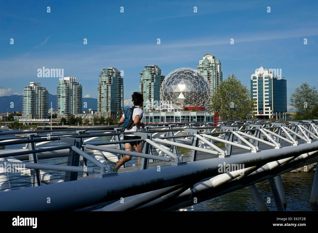 Jogger über die Kanu Brücke in False Creek Village, Vancouver, British Columbia, Kanada läuft Stockfoto