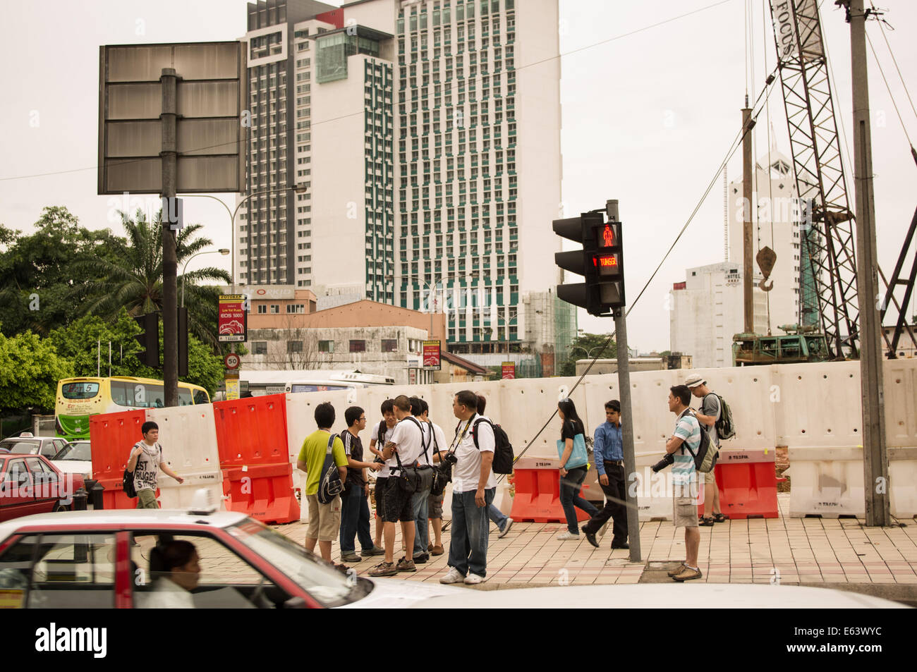 Touristen mit Kamera versucht, die Straße überqueren die Ampel auf Grün warten Stockfoto