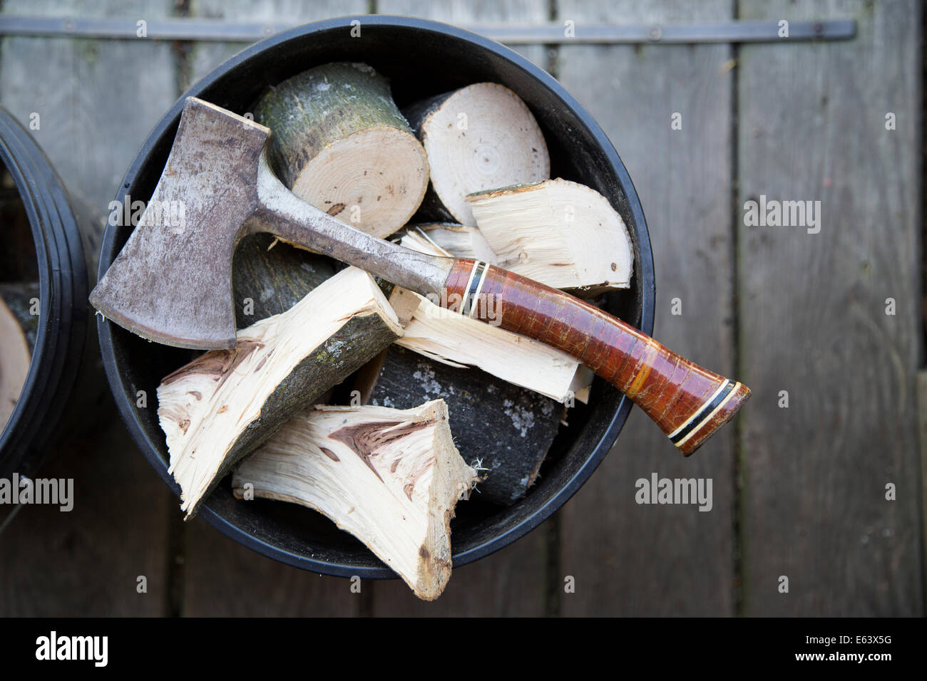 ein Beil sitzt auf einem Eimer gefüllt mit Stücken von Hickory und andere Hölzer, wichtig für den Geschmack in den Grill Räuchern. Stockfoto