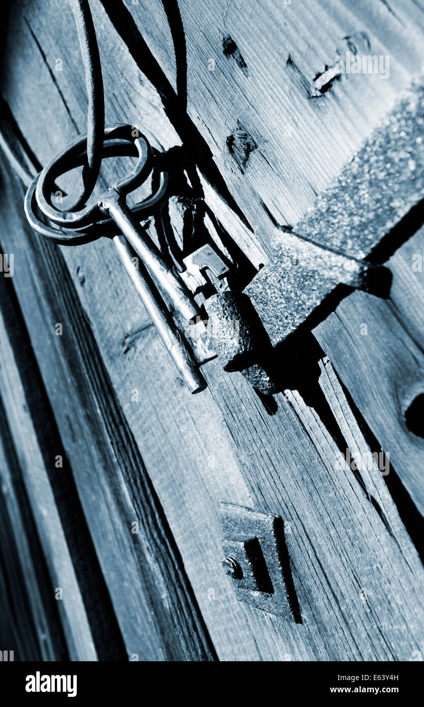 Antike Schlüssel hängen an einer verbleiten Fensterecke Stockfoto