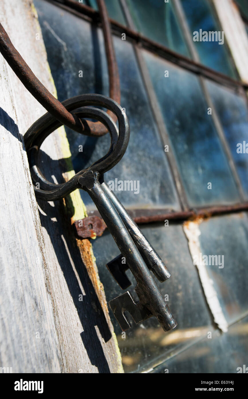 alte antike Schlüssel gegen einen gefärbten verbleit, Fenster und Rahmen Stockfoto