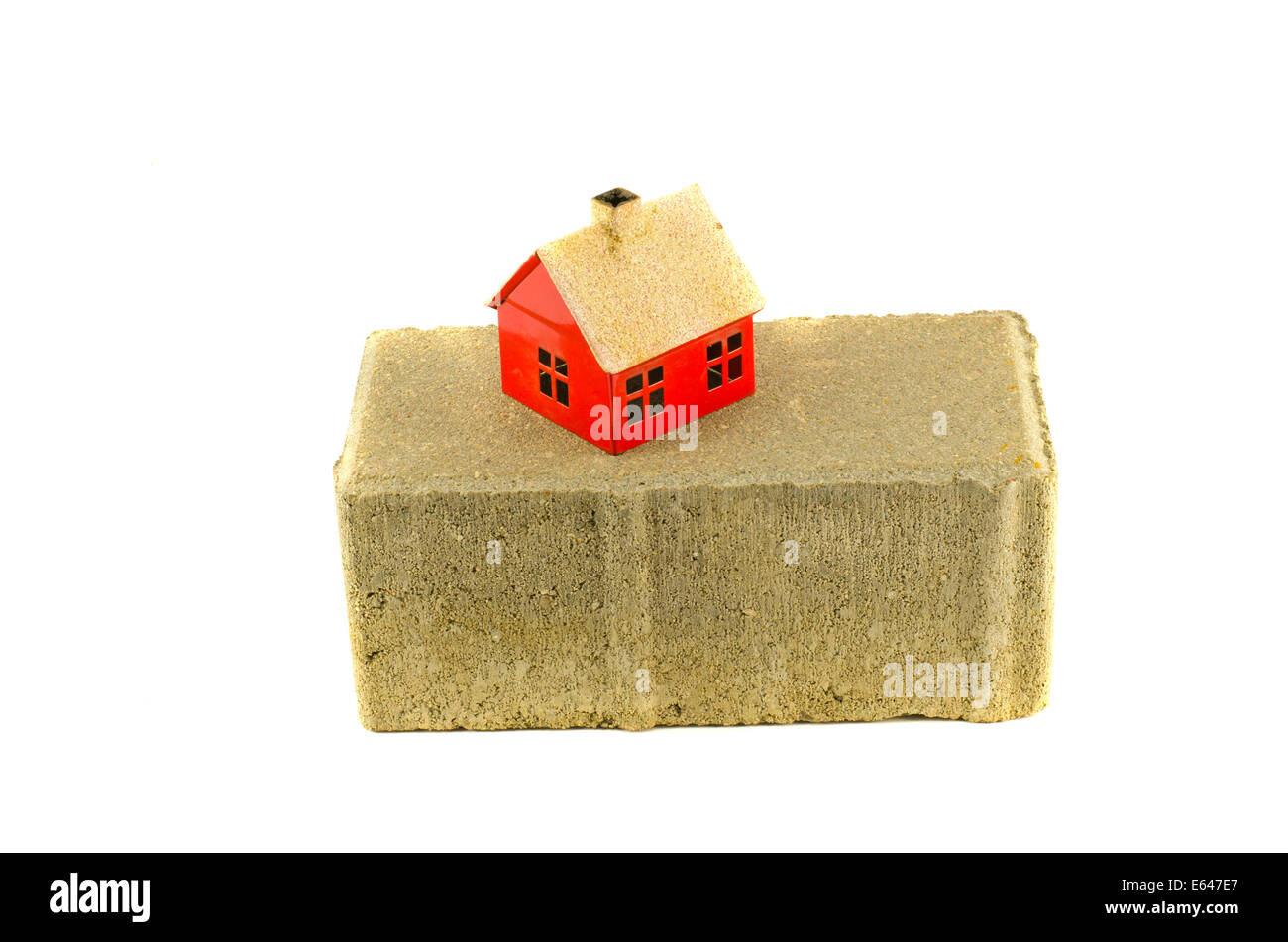 graue industrielle Ziegel und kleines Hausmodell isoliert auf weiss. Gebäudekonzept Stockfoto