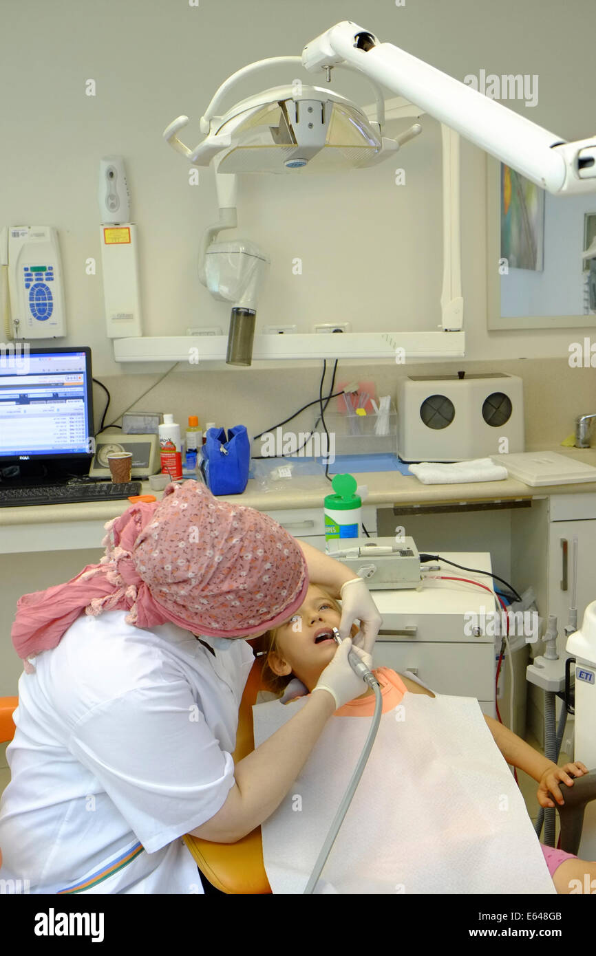 Junges Mädchen hat ihre Zähne gereinigt durch eine Dentalhygienikerin beim Zahnarzt Stockfoto