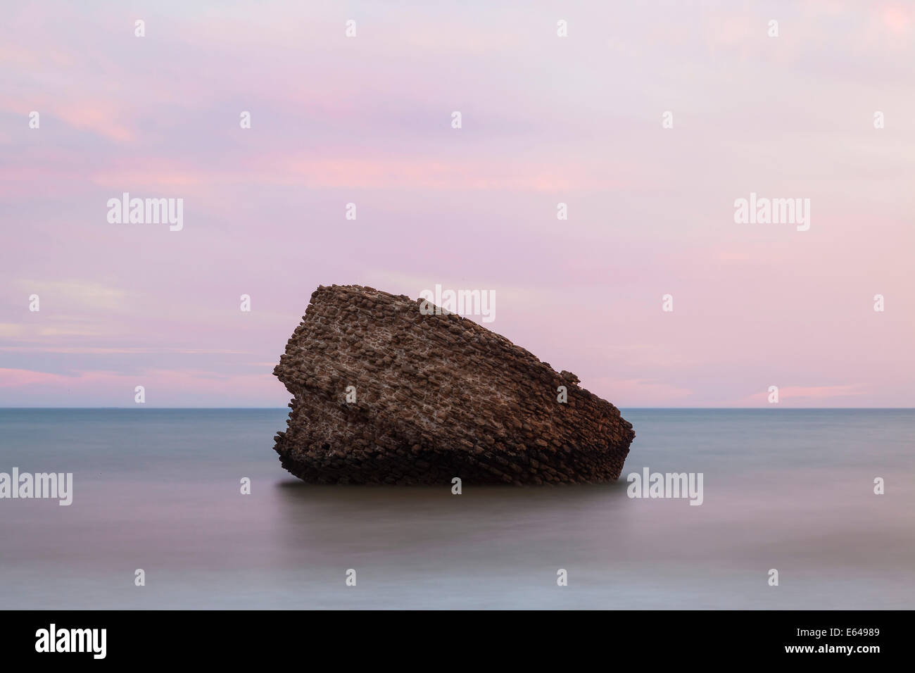 Rock (einem alten Wachturm oder Leuchtfeuer) am Strand von Matalascañas bei Sonnenuntergang, Andalusien, Spanien Stockfoto