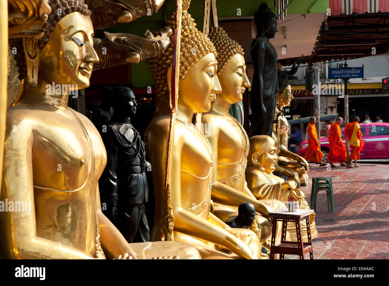 Buddha-Statuen, Mönche und Tuk Tuk, Straßenszene, Bangkok, Thailand Stockfoto