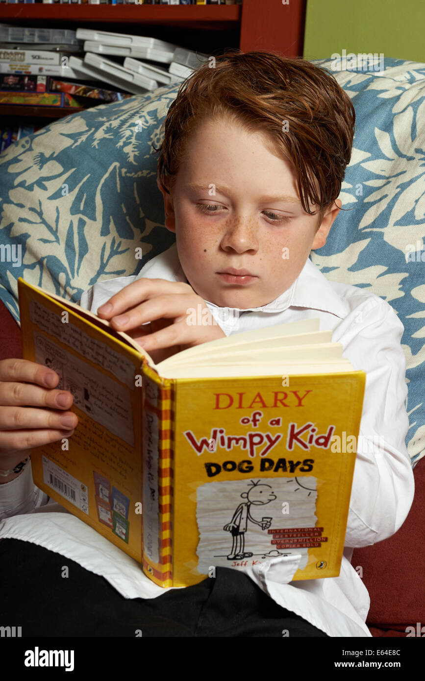 Junge zu Hause nach der Schule ein Buch lesen Stockfoto